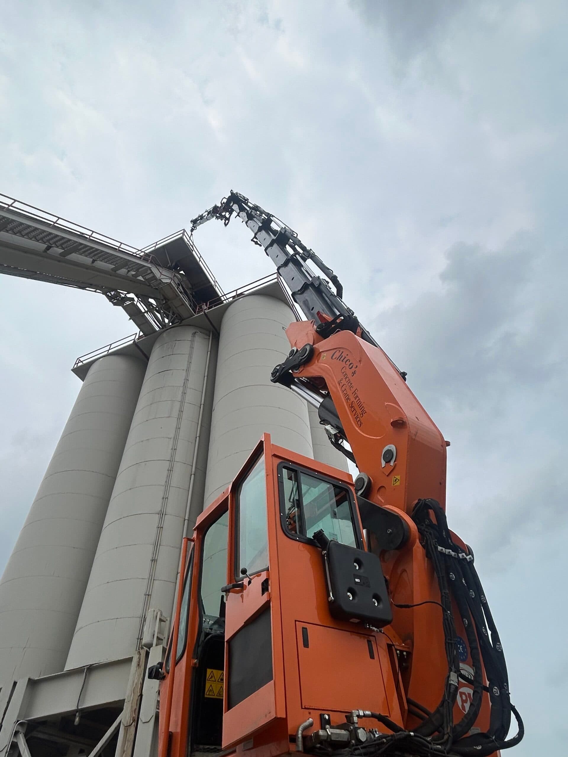 Crane service lifting motor to the top of 100 ft silo. Complex industrial installation requiring precision